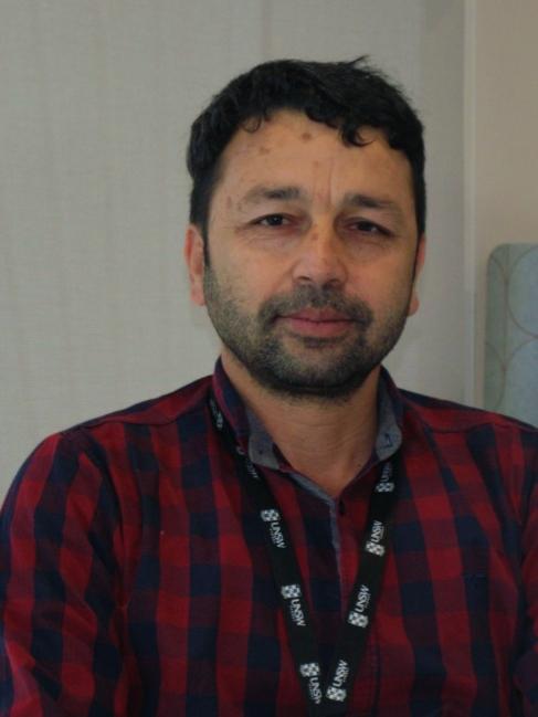 A profile photo of Manzoor Khan. He is wearing a red and blue check shirt.