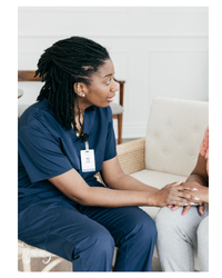 Photo of a woman in scrubs holding someone's hand.