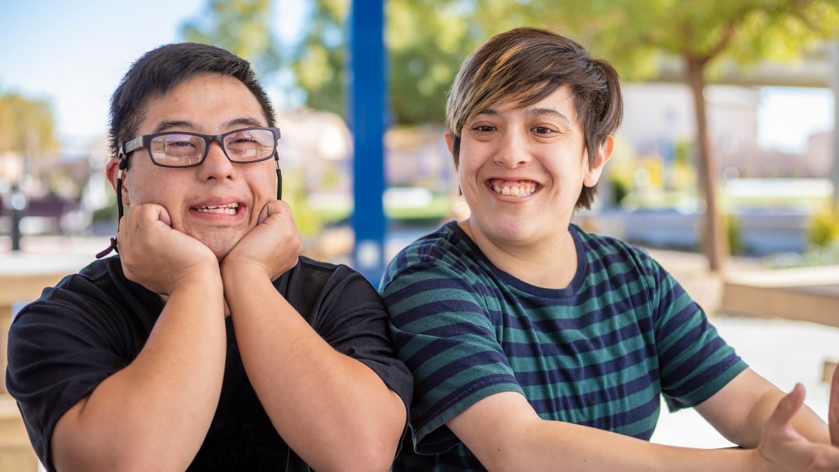 Two young people with intellectual disability looking happy.