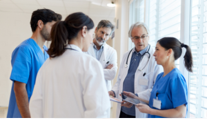 A group of health professionals in a hospital standing and talking together.