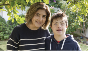 Photo of a mum and her young son who has intellectual disability. They are outside under a tree.