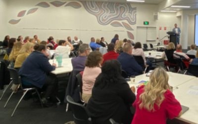 Photo of a group of people at the roundtable watching a presentation.