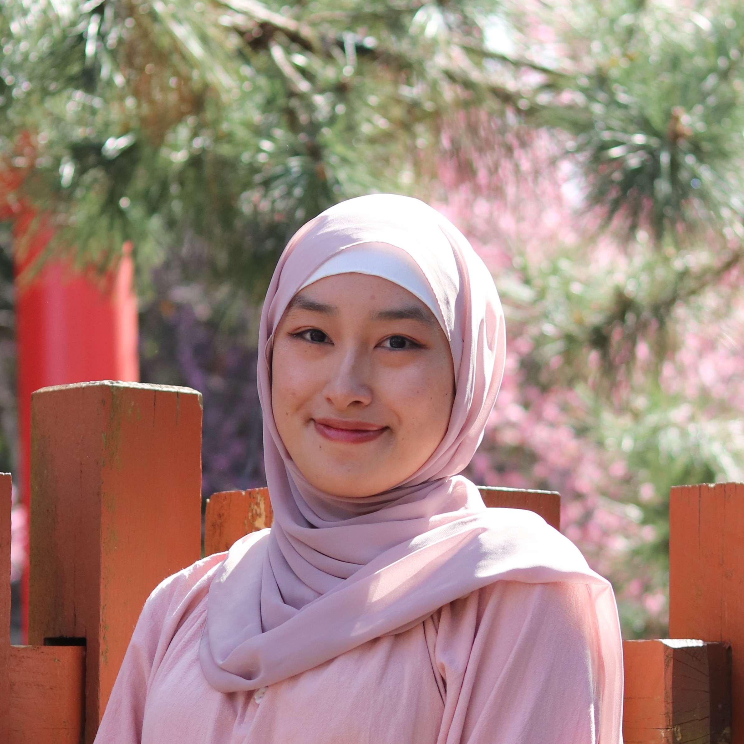 Photo of Aminah Thipayawat. She is wearing pink and smiling at the camera.