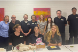 Photo of a group of people standing together and smiling at the camera.