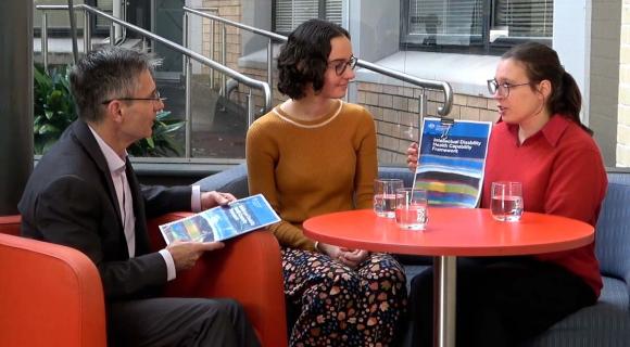 Tahli, Emily and Julian sitting at a cafe table talking about the framework. 