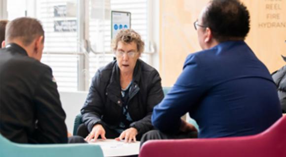 Members of a group sitting around a table planning