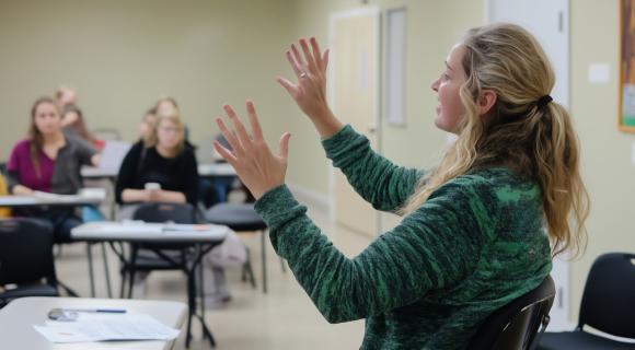 A person teaching a class of health professionals 