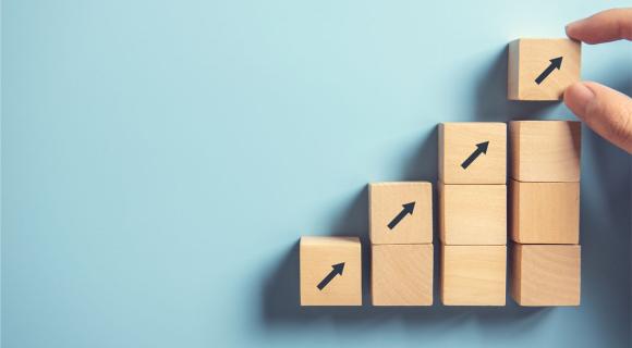 A person building a staircase out of wooden blocks