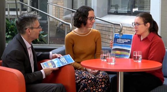 Team members Julian and Tahli at a cafe talking with Emily about the framework