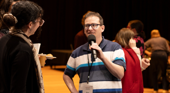 Photo of Ricky Kremer from the Centre holding a microphone and talking to people.