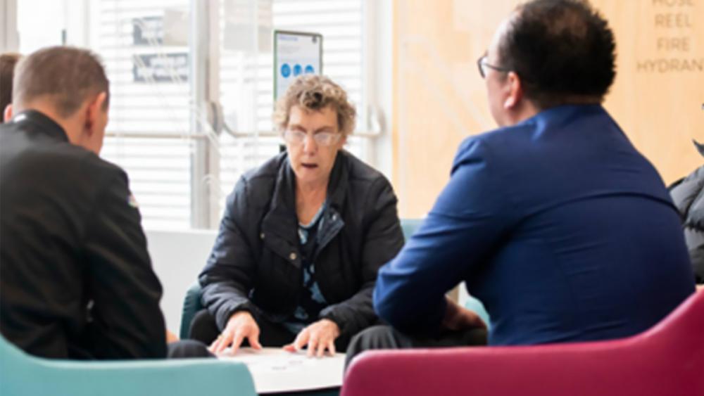 Members of a group sitting around a table planning