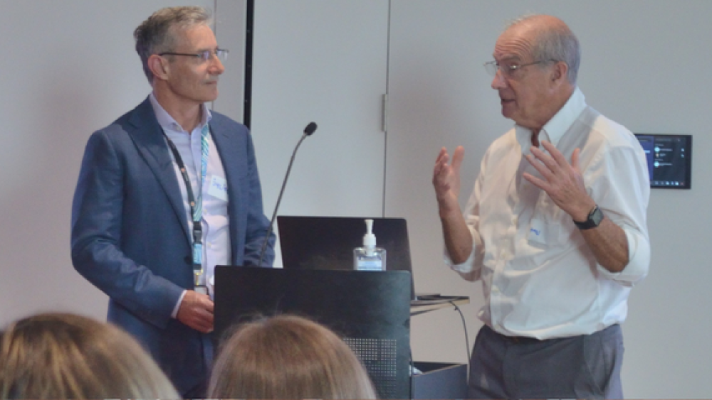 A photo of Professor Julian Trollor and Professor Tony Holland at a presentation. They are in front of an audience talking to each other.