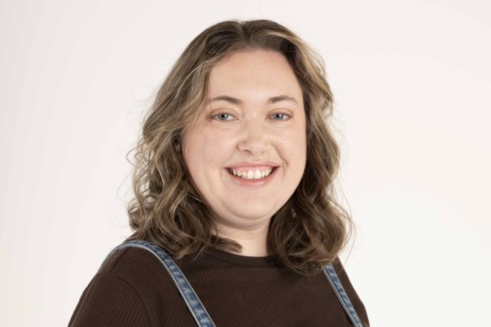 Photo of Alanna Julian. She is wearing a brown top and smiling at the camera.