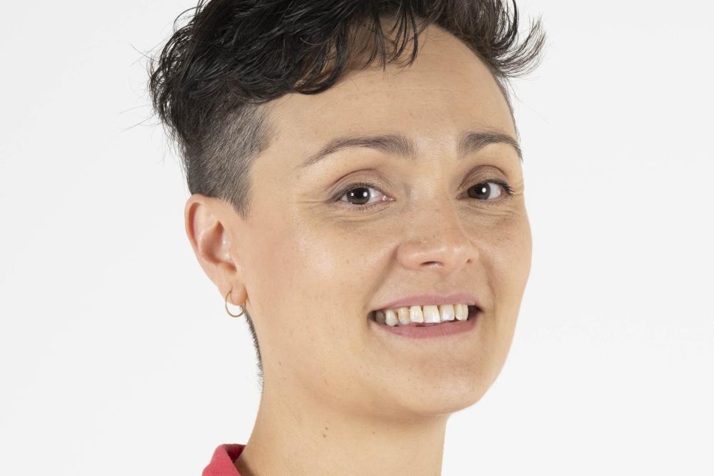 Photo of Cat Standley. She is wearing a pink top and smiling at the camera.